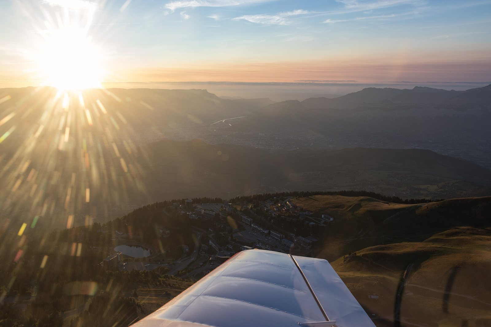 Vue aérienne depuis Belledonne vers l'Est, bassin grenoblois et Vercors, soleil en contre jour au ras du Vercors