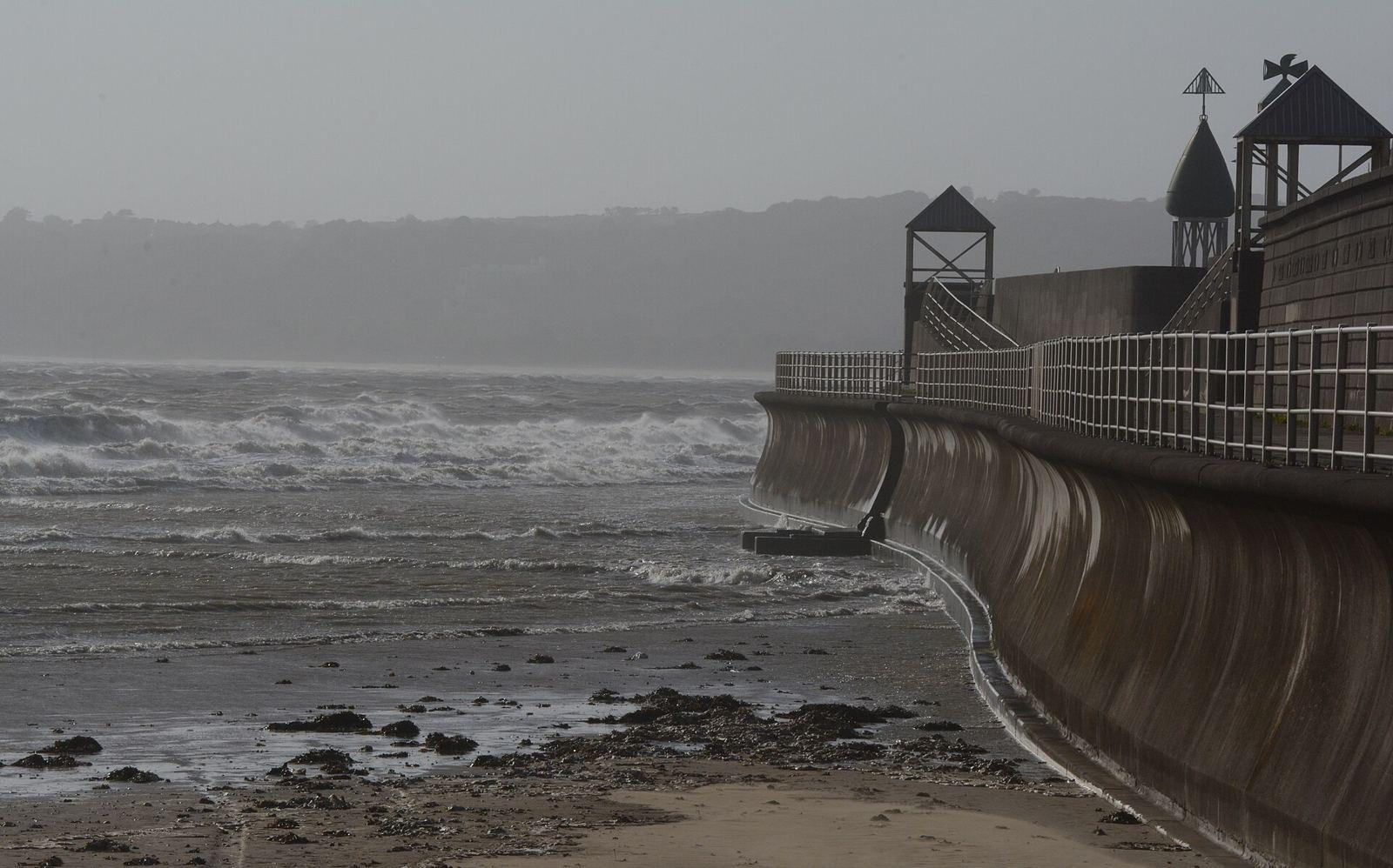The Sea Wall at Swansea Bay waiting for the incoming tide and the unrestrained energy of downgraded tropical storm Ophelia. The hillside in the distance is partly obscured by the considerable amounts 
