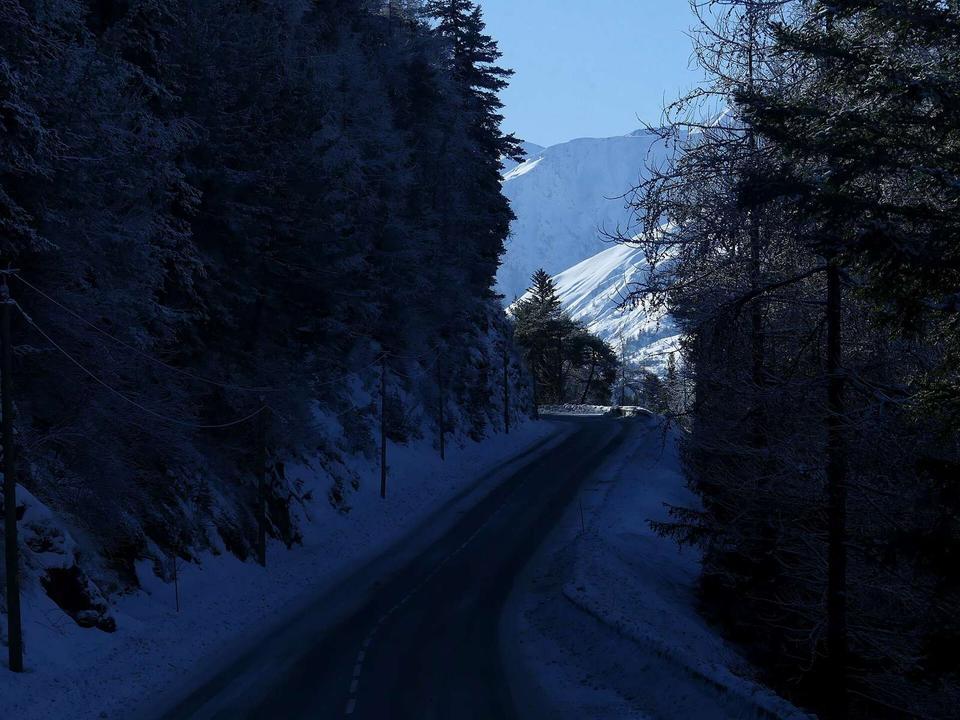 Sight, in winter, of Route départementale 902 road between Col du Télégraphe pass and Valloire (ahead), in Savoie, France.