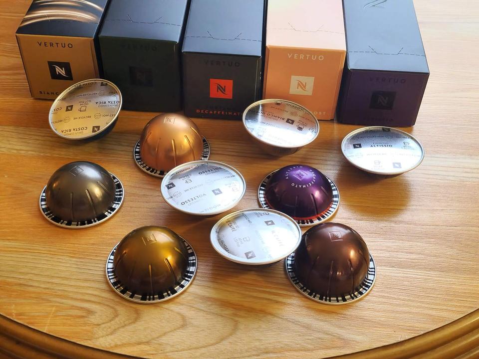 An assortment of Nespresso Vertuo Coffee Pods lie in front of boxes of Nespresso Pods.